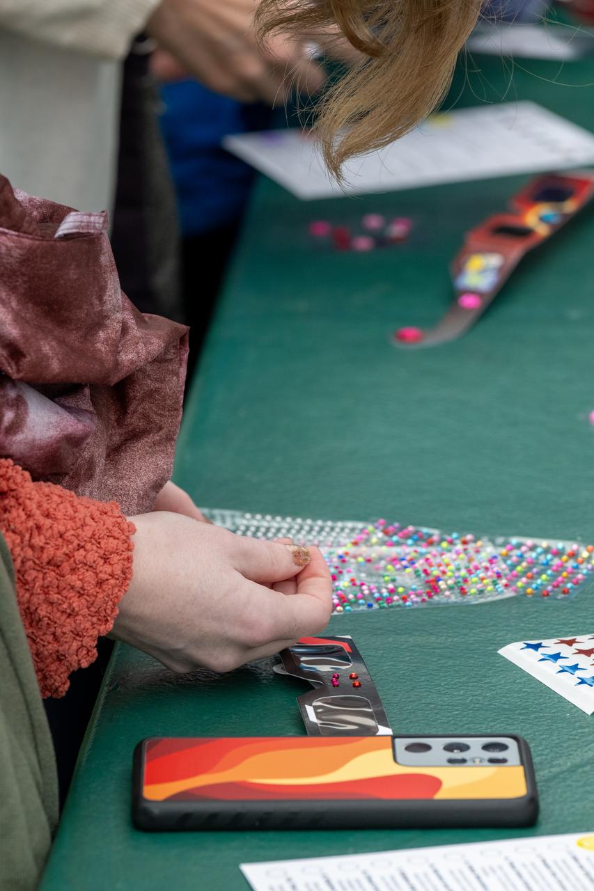 Guests decorate their protective glasses at the Dallas Arboretum prior to the total solar eclipse, Monday, April 8, 2024, in Dallas, Texas. A total solar eclipse swept across a narrow portion of the North American continent from Mexico’s Pacific coast to the Atlantic coast of Newfoundland, Canada. A partial solar eclipse was visible across the entire North American continent along with parts of Central America and Europe. Photo Credit: (NASA/Keegan Barber) in Dallas, Texas on Monday, April 8, 2024. A total solar eclipse swept across a narrow portion of the North American continent from Mexico’s Pacific coast to the Atlantic coast of Newfoundland, Canada. A partial solar eclipse was visible across the entire North American continent along with parts of Central America and Europe. Photo Credit: (NASA/Keegan Barber)