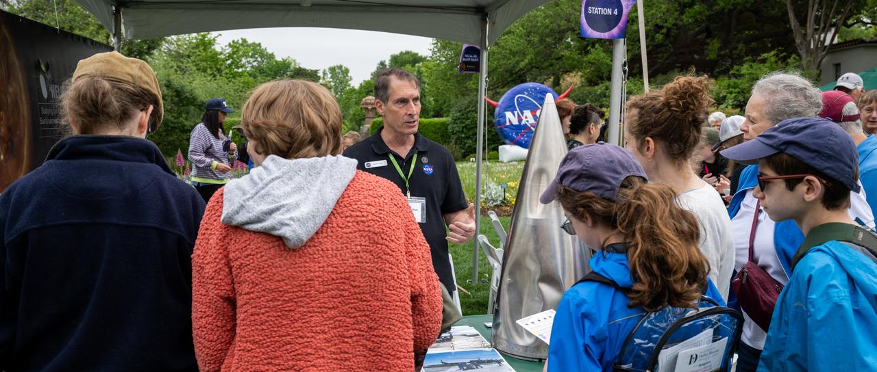 Guests learn about the total solar eclipse from NASA staff at the Dallas Arboretum, Monday, April 8, 2024, in Dallas, Texas. A total solar eclipse swept across a narrow portion of the North American continent from Mexico’s Pacific coast to the Atlantic coast of Newfoundland, Canada. A partial solar eclipse was visible across the entire North American continent along with parts of Central America and Europe. Photo Credit: (NASA/Keegan Barber) in Dallas, Texas on Monday, April 8, 2024. A total solar eclipse swept across a narrow portion of the North American continent from Mexico’s Pacific coast to the Atlantic coast of Newfoundland, Canada. A partial solar eclipse was visible across the entire North American continent along with parts of Central America and Europe. Photo Credit: (NASA/Keegan Barber)
