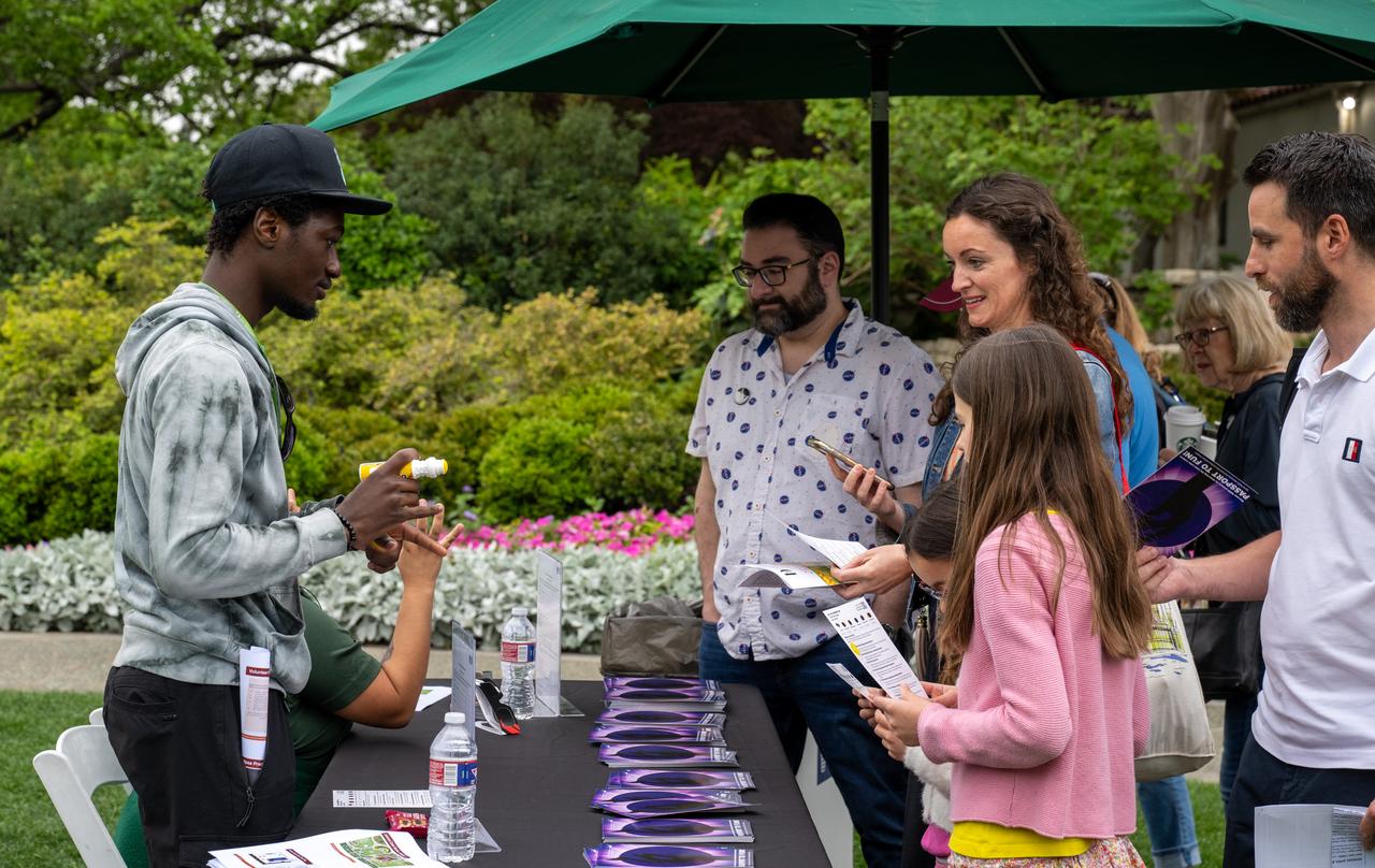 Guests learn about the total solar eclipse from NASA staff at the Dallas Arboretum, Monday, April 8, 2024, in Dallas, Texas. A total solar eclipse swept across a narrow portion of the North American continent from Mexico’s Pacific coast to the Atlantic coast of Newfoundland, Canada. A partial solar eclipse was visible across the entire North American continent along with parts of Central America and Europe. Photo Credit: (NASA/Keegan Barber) in Dallas, Texas on Monday, April 8, 2024. A total solar eclipse swept across a narrow portion of the North American continent from Mexico’s Pacific coast to the Atlantic coast of Newfoundland, Canada. A partial solar eclipse was visible across the entire North American continent along with parts of Central America and Europe. Photo Credit: (NASA/Keegan Barber)