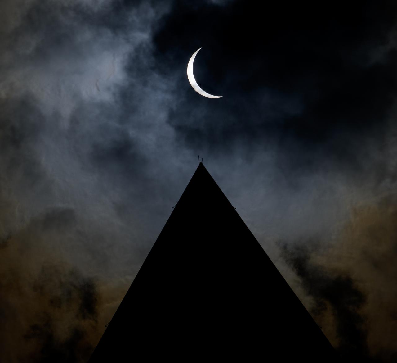 The Moon is seen passing in front of the Sun, with the top of the Washington Monument in silhouette, during a partial solar eclipse in Washington, on Monday, April 8, 2024. A total solar eclipse swept across a narrow portion of the North American continent from Mexico’s Pacific coast to the Atlantic coast of Newfoundland, Canada. A partial solar eclipse was visible across the entire North American continent along with parts of Central America and Europe.  Photo Credit: (NASA/Bill Ingalls)