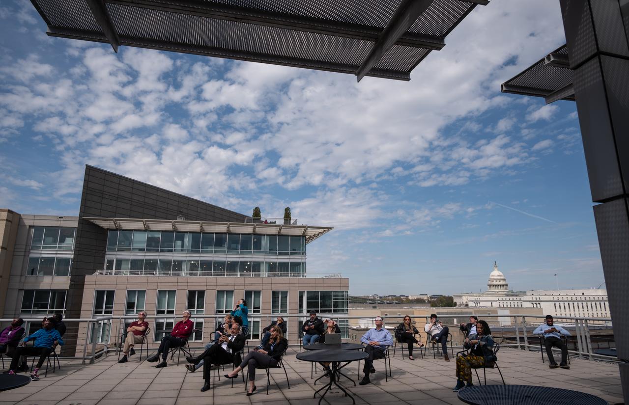 People gather on the roof of NASA Headquarters in Washington to watch a partial solar eclipse through protective glasses in Washington, on Monday, April 8, 2024. A total solar eclipse swept across a narrow portion of the North American continent from Mexico’s Pacific coast to the Atlantic coast of Newfoundland, Canada. A partial solar eclipse was visible across the entire North American continent along with parts of Central America and Europe.  Photo Credit: (NASA/Connie Moore)