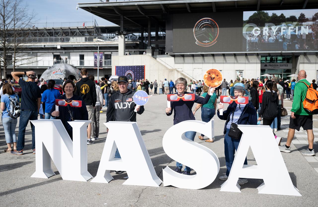 Attendees at the Indianapolis Motor Speedway pose for pictures on Pagoda Plaza ahead of the total solar eclipse, Monday, April 8, 2024, in Indianapolis, Ind. A total solar eclipse swept across a narrow portion of the North American continent from Mexico’s Pacific coast to the Atlantic coast of Newfoundland, Canada. A partial solar eclipse was visible across the entire North American continent along with parts of Central America and Europe.  Photo Credit: (NASA/Joel Kowsky)