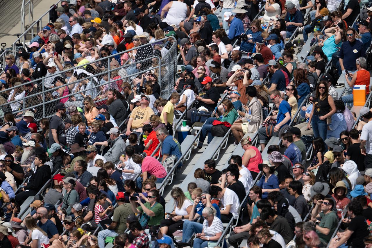 Attendees view the progression of a total solar eclipse from the Indianapolis Motor Speedway, Monday, April 8, 2024, in Indianapolis, Indiana. A total solar eclipse swept across a narrow portion of the North American continent from Mexico’s Pacific coast to the Atlantic coast of Newfoundland, Canada. A partial solar eclipse was visible across the entire North American continent along with parts of Central America and Europe.  Photo Credit: (NASA/Joel Kowsky)
