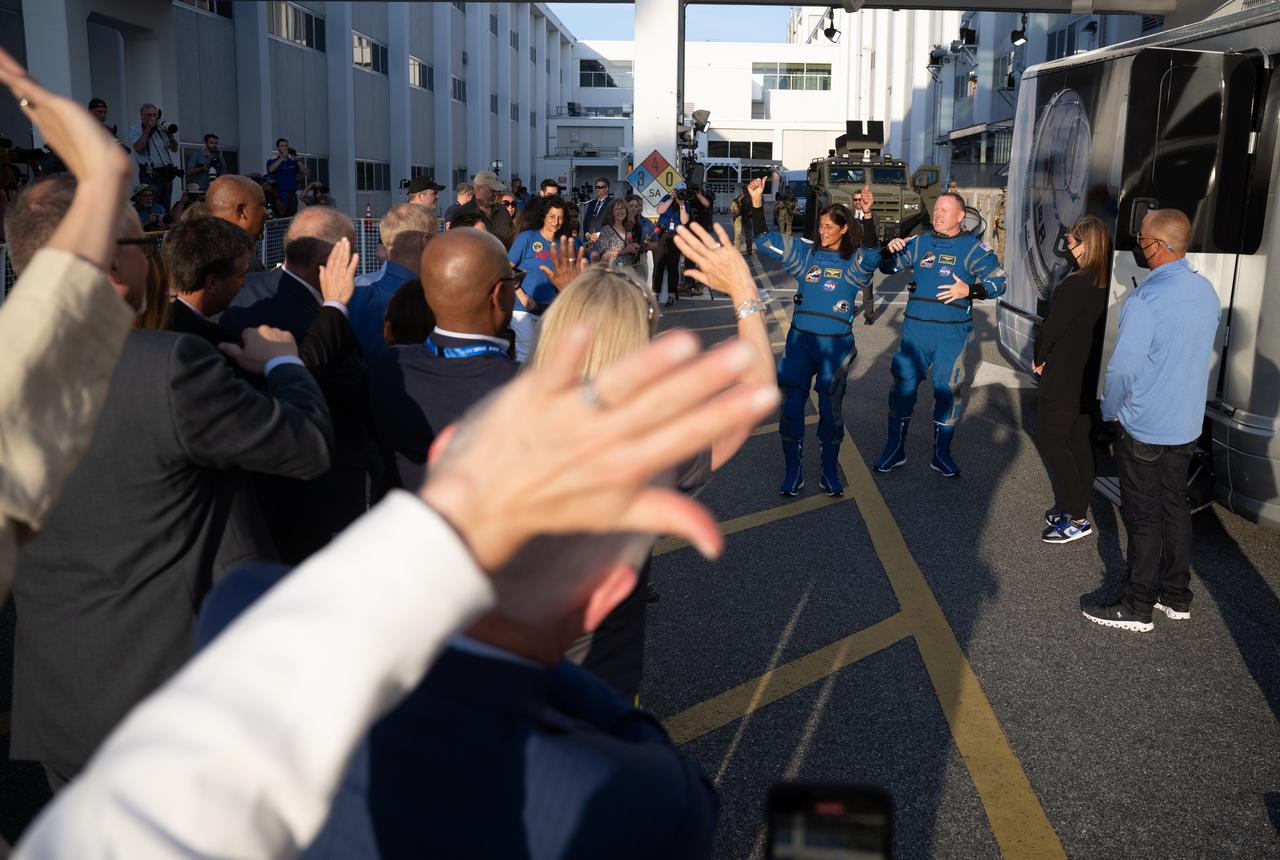 NASA astronauts Suni Williams, left, and Butch Wilmore, wearing Boeing spacesuits, wave as they prepare to depart the Neil A. Armstrong Operations and Checkout Building for Launch Complex 41 on Cape Canaveral Space Force Station to board the Boeing CST-100 Starliner spacecraft for the Crew Flight Test launch, Monday, May 6, 2024, at NASA’s Kennedy Space Center in Florida. NASA’s Boeing Crew Flight Test is the first launch with astronauts of the Boeing CFT-100 spacecraft and United Launch Alliance Atlas V rocket to the International Space Station as part of the agency’s Commercial Crew Program. The flight test, targeted for launch at 10:34 p.m. EDT on Monday, May 6, serves as an end-to-end demonstration of Boeing’s crew transportation system and will carry NASA astronauts Butch Wilmore and Suni Williams to and from the orbiting laboratory. Photo Credit: (NASA/Joel Kowsky)