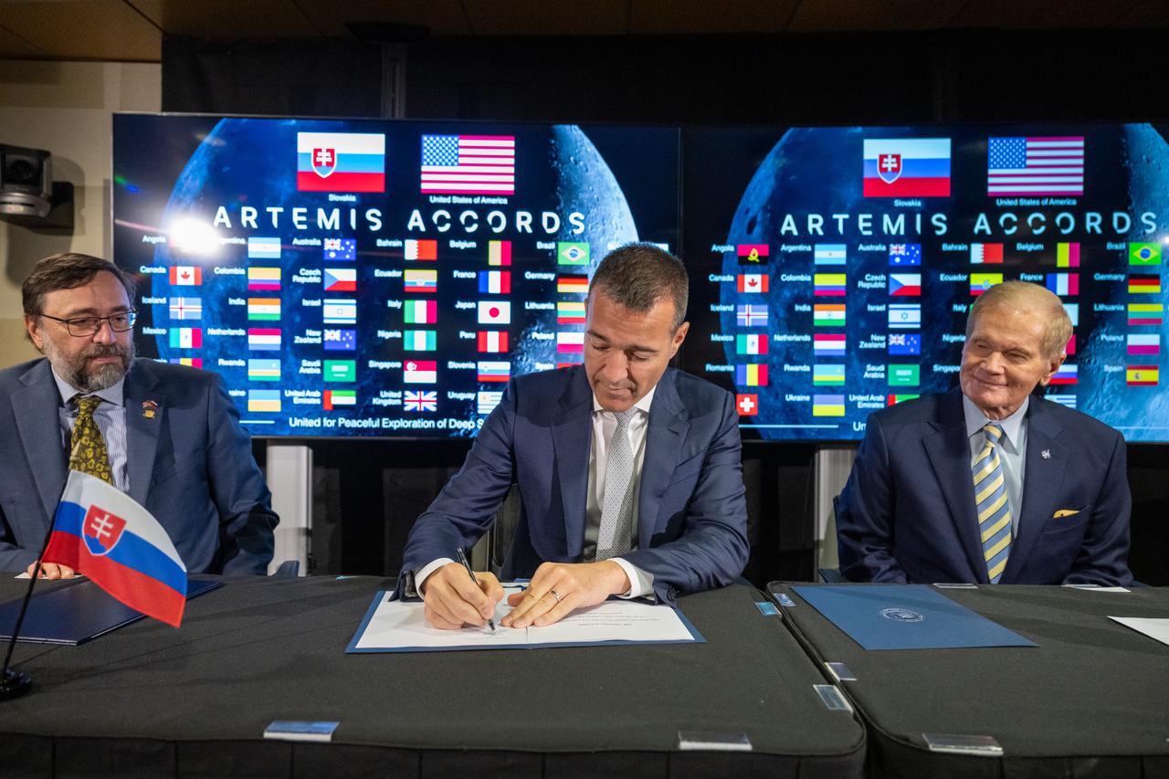 Slovak Republic Minister of Education, Research, Development, and Youth Tomáš Drucker signs the Artemis Accords as NASA Administrator Bill Nelson, right, and Ambassador of the Slovak Republic to the United States Radovan Javorcik, left, look on, Thursday, May 30, 2024, at the Mary W. Jackson NASA Headquarters building in Washington. Slovakia is the 42nd country to sign the Artemis Accords, which establish a practical set of principles to guide space exploration cooperation among nations participating in NASA’s Artemis program. Photo Credit: (NASA/Keegan Barber)