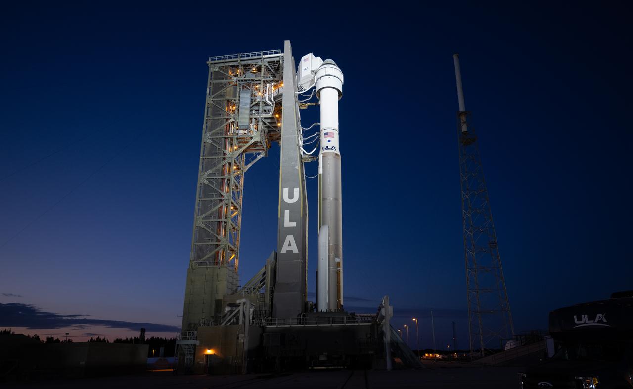 A United Launch Alliance Atlas V rocket with Boeing’s CST-100 Starliner spacecraft aboard is seen illuminated by spotlights at sunset on the launch pad at Space Launch Complex 41 ahead of the NASA’s Boeing Crew Flight Test, Thursday, May 30, 2024 at Cape Canaveral Space Force Station in Florida. NASA’s Boeing Crew Flight Test is the first launch with astronauts of the Boeing CFT-100 spacecraft and United Launch Alliance Atlas V rocket to the International Space Station as part of the agency’s Commercial Crew Program. The flight test, targeted for launch at 12:25 p.m. EDT on Saturday, June 1, serves as an end-to-end demonstration of Boeing’s crew transportation system and will carry NASA astronauts Butch Wilmore and Suni Williams to and from the orbiting laboratory. Photo Credit: (NASA/Joel Kowsky)