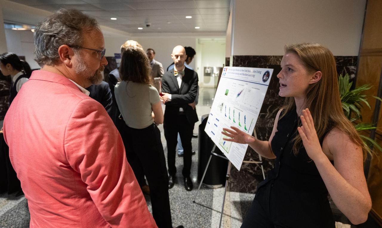 Members of the Climate Change Research Initiative (CCRI) cohort discuss their research during a poster session, Wednesday, Aug. 7, 2024, at the Mary W. Jackson NASA Headquarters building in Washington, DC. The Earth Science Division’s Early Career Research Program’s Climate Change Research Initiative (CCRI) is a year-long STEM engagement and experiential learning opportunity for educators and students from high school to graduate level. Photo Credit: (NASA/Joel Kowsky)