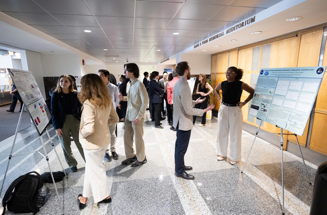 Members of the Climate Change Research Initiative (CCRI) cohort discuss their research during a poster session, Wednesday, Aug. 7, 2024, at the Mary W. Jackson NASA Headquarters building in Washington, DC. The Earth Science Division’s Early Career Research Program’s Climate Change Research Initiative (CCRI) is a year-long STEM engagement and experiential learning opportunity for educators and students from high school to graduate level. Photo Credit: (NASA/Joel Kowsky)