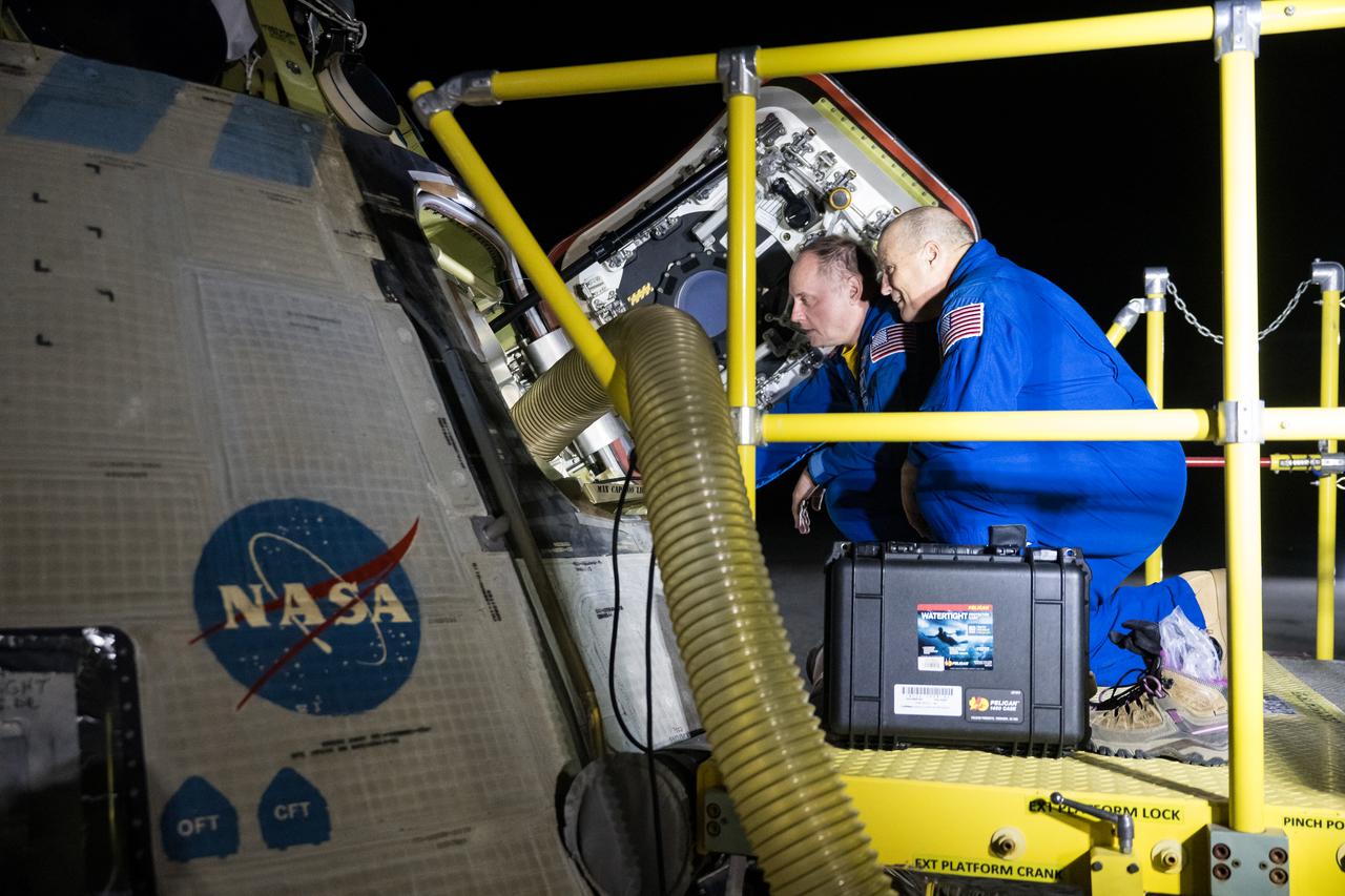 NASA astronauts Mike Fincke, left, and Scott Tingle look inside NASA's Boeing Crew Flight Test Starliner spacecraft after it landed uncrewed at White Sands Missile Range’s Space Harbor, Friday, Sept. 6, 2024 Mountain Time (Sept. 7 Eastern Time), in New Mexico. This approach allows NASA and Boeing to continue gathering testing data on the spacecraft. Photo Credit: (NASA/Aubrey Gemignani)