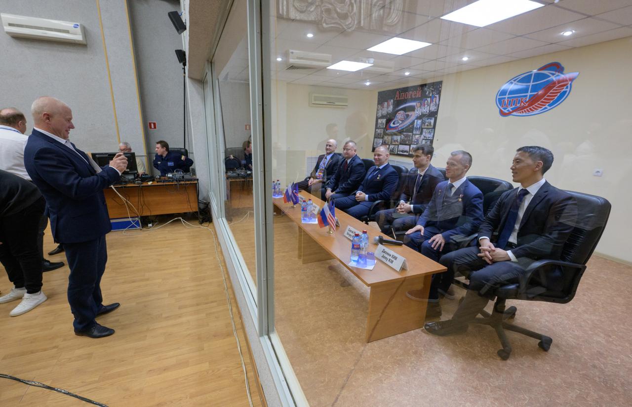 Expedition 72 crew members, in quarantine behind glass: NASA astronaut Don Pettit, left, Roscosmos cosmonauts Alexey Ovchinin, and Ivan Vagner, and backup crew members Alexey Zubritskiy, Sergey Ryzhikov, both of Roscosmos, and Jonny Kim of NASA, right, are photographed by Cosmonaut Oleg Novitsky at the conclusion of the State Commission meeting to approve the Soyuz launch of the prime crew to the International Space Station, Tuesday, Sept. 10, 2024 at the Cosmonaut Hotel in Baikonur, Kazakhstan. The trio are scheduled to launch aboard their Soyuz MS-26 spacecraft on September 11. Photo Credit: (NASA/Bill Ingalls)