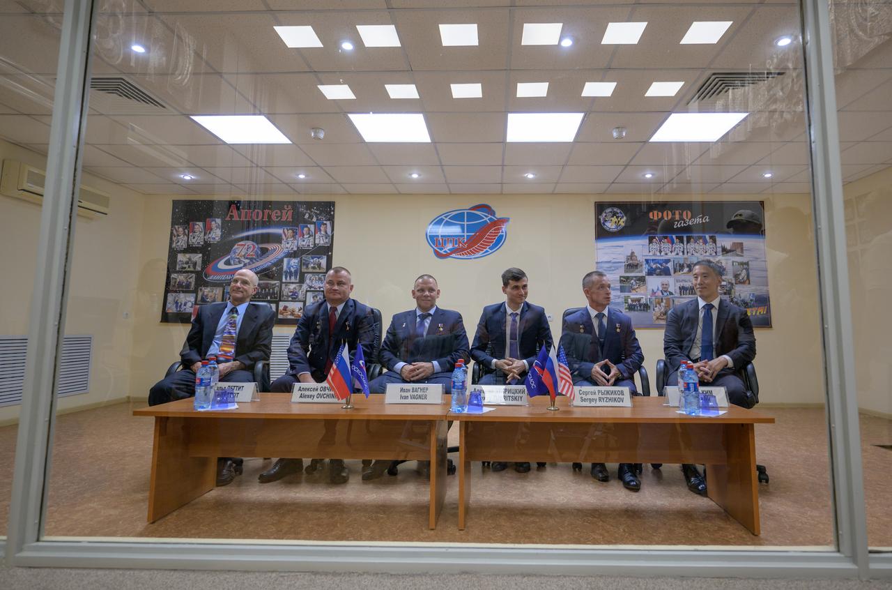 Expedition 72 crew members, in quarantine behind glass: NASA astronaut Don Pettit, left, Roscosmos cosmonauts Alexey Ovchinin, and Ivan Vagner, and backup crew members Alexey Zubritskiy, Sergey Ryzhikov, both of Roscosmos, and Jonny Kim of NASA, right, are seen during the State Commission meeting to approve the Soyuz launch of the Expedition 72 crew to the International Space Station, Tuesday, Sept. 10, 2024 at the Cosmonaut Hotel in Baikonur, Kazakhstan. The trio are scheduled to launch aboard their Soyuz MS-26 spacecraft on September 11. Photo Credit: (NASA/Bill Ingalls)
