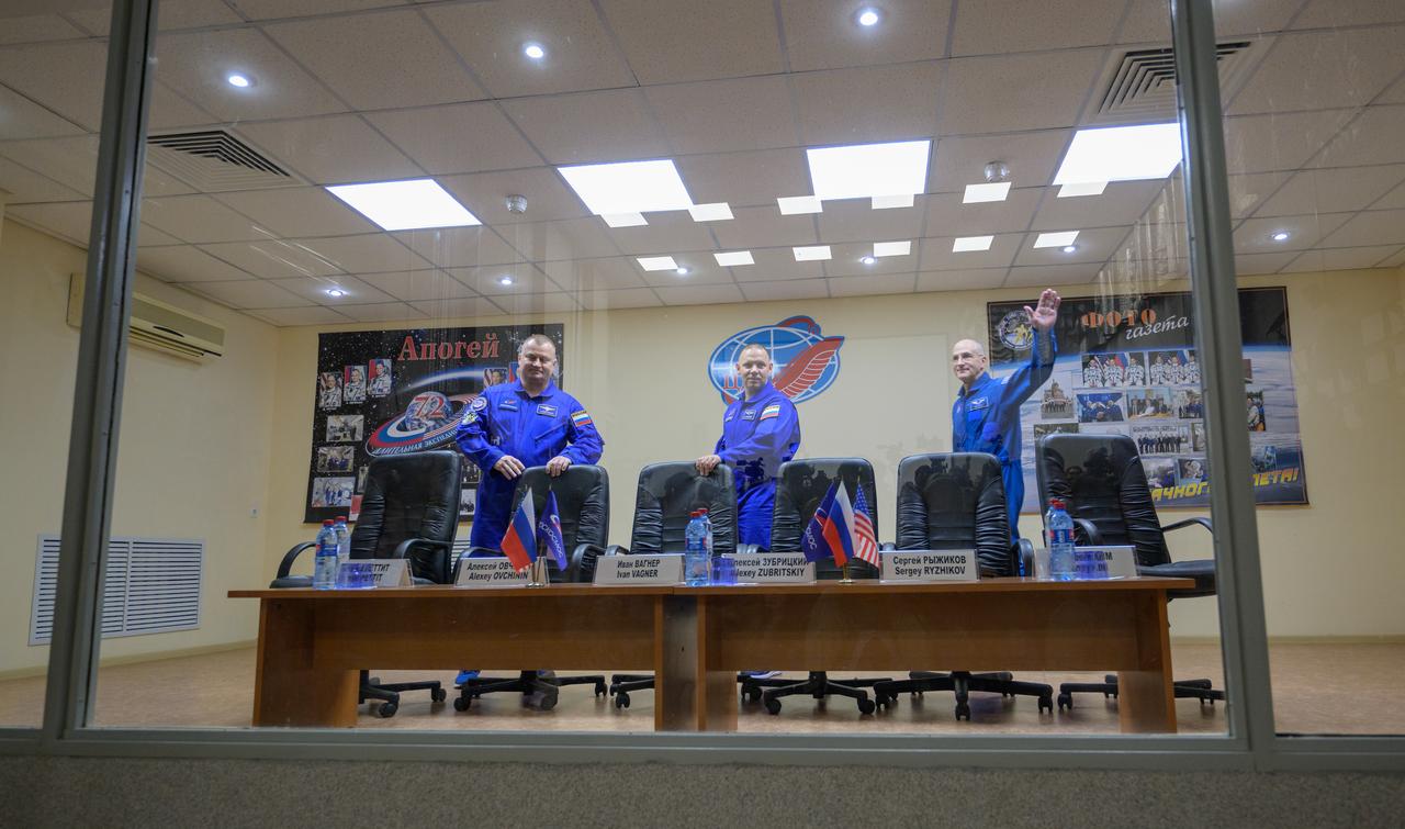 Expedition 72 crew members: Roscosmos cosmonauts Alexey Ovchinin, left, Ivan Vagner, and NASA astronaut Don Pettit, right, are seen in quarantine, behind glass, during a press conference, Tuesday, Sept. 10, 2024 a the Cosmonaut Hotel in Baikonur, Kazakhstan. The trio are scheduled to launch aboard their Soyuz MS-26 spacecraft on September 11. Photo Credit: (NASA/Bill Ingalls)