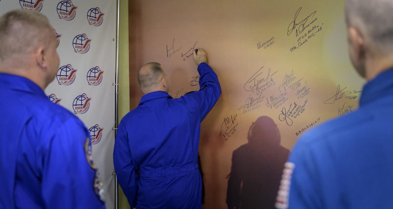 Roscosmos cosmonaut Ivan Vagner signs a mural at the Cosmonaut Hotel prior to departing for suit-up and launch on a Soyuz rocket with fellow crew mates, Roscosmos cosmonaut Alexey Ovchinin, and NASA astronaut Don Pettit, Wednesday, Sept. 11, 2024, in Baikonur, Kazakhstan. The launch will send Pettit, Ovchinin, Vagner, on a mission to the International Space Station. Photo Credit: (NASA/Bill Ingalls)