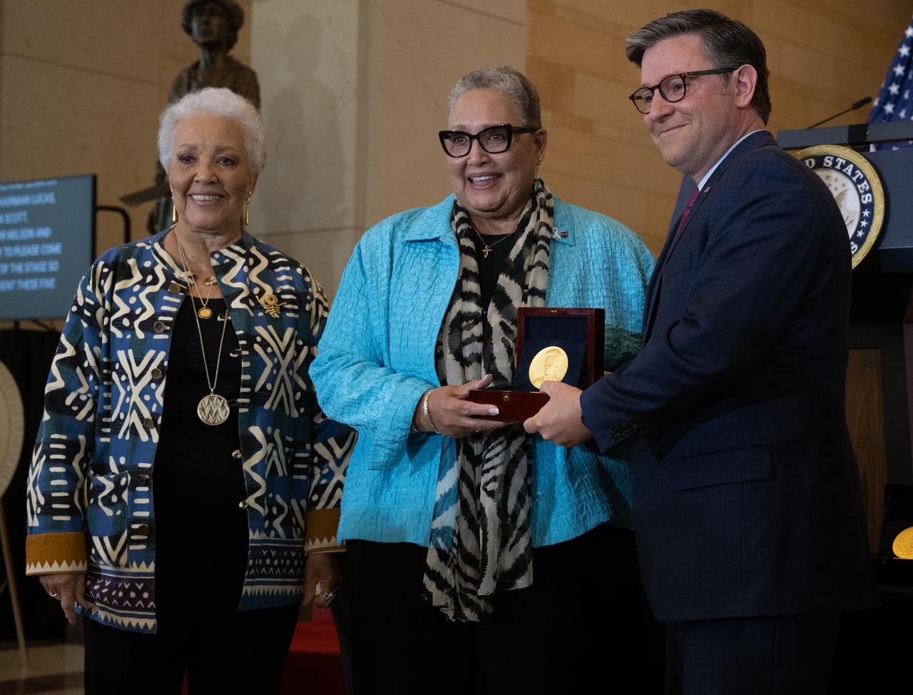 Joylette Hylick, left, and Katherine Moore, daughters of Katherine Johnson, accept the Congressional Gold Medal on behalf of Katherine Johnson from Speaker of the House Mike Johnson (R-LA) during a ceremony recognizing NASA’s Hidden Figures, Wednesday, Sept. 18, 2024, in Emancipation Hall at the U.S. Capitol in Washington. Congressional Gold Medals were awarded to Katherine Johnson, Dr. Christine Darden, Dorothy Vaughan, and Mary W. Jackson in recognition of their service to the United States as well as a Congressional Gold Medal in recognition of all the women who served as computers, mathematicians, and engineers at the National Advisory Committee for Aeronautics and NASA between the 1930s and 1970s.  Photo Credit: (NASA/Joel Kowsky)