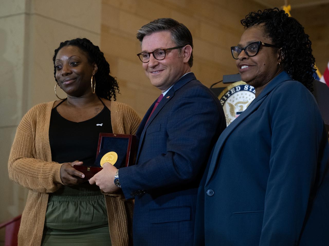 KaShawnta Lee, left, and Wanda Jackson, right, granddaughters of Mary W. Jackson, accept the Congressional Gold Medal on behalf of Mary W. Jackson from Speaker of the House Mike Johnson (R-LA), center, during a ceremony recognizing NASA’s Hidden Figures, Wednesday, Sept. 18, 2024, in Emancipation Hall at the U.S. Capitol in Washington. Congressional Gold Medals were awarded to Katherine Johnson, Dr. Christine Darden, Dorothy Vaughan, and Mary W. Jackson in recognition of their service to the United States as well as a Congressional Gold Medal in recognition of all the women who served as computers, mathematicians, and engineers at the National Advisory Committee for Aeronautics and NASA between the 1930s and 1970s.  Photo Credit: (NASA/Joel Kowsky)