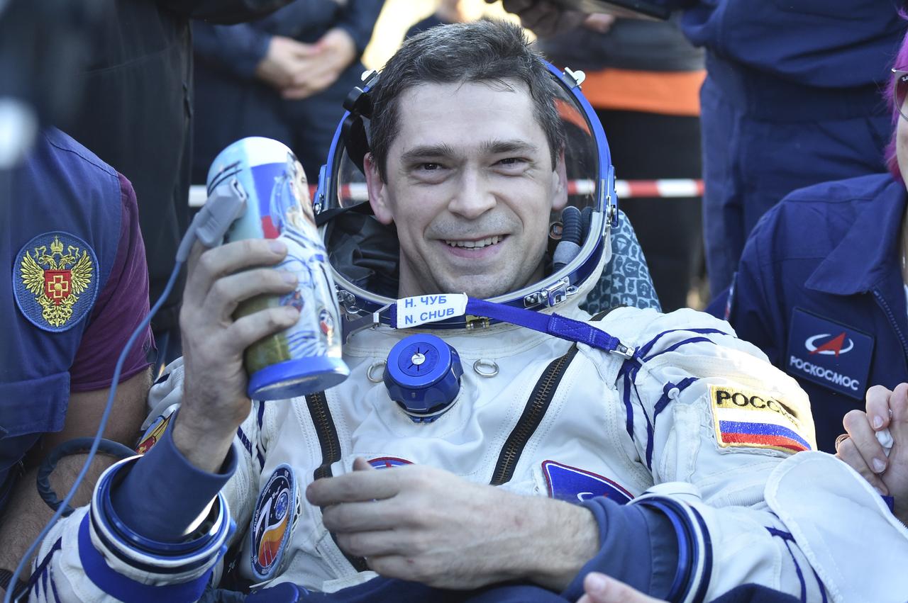 Roscosmos cosmonaut Nikolai Chub is seen smiling and holding a gifted matryoshka doll is seen outside the Soyuz MS-25 spacecraft after he landed with Roscosmos cosmonaut Oleg Kononenko, and NASA astronaut Tracy C. Dyson, in a remote area near the town of Zhezkazgan, Kazakhstan on Monday, Sept. 23, 2024. Dyson is returning to Earth after logging 184 days in space as a member of Expeditions 70-71 aboard the International Space Station and Chub and Kononenko return after having spent the last 374 days in space. Photo Credit NASA/GCTC/Pavel Shvets