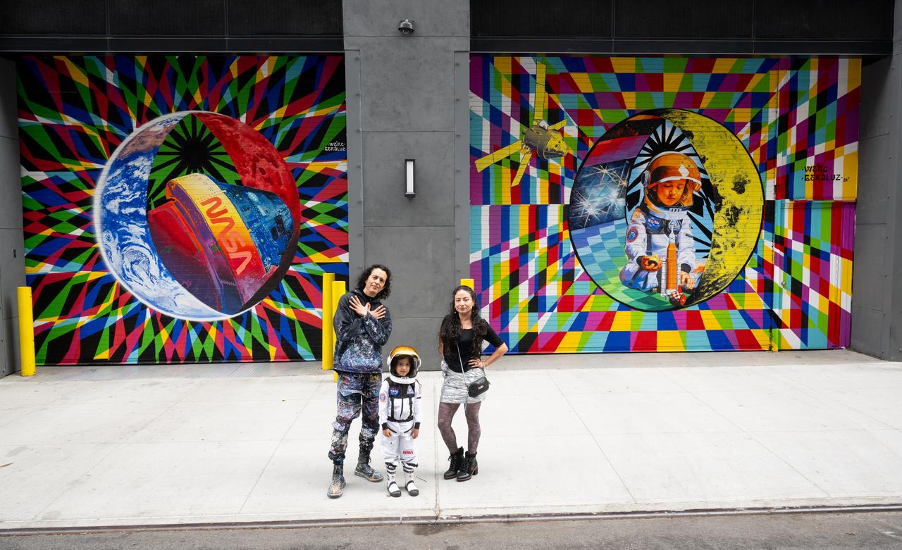The New York-based artist team Geraluz, left, and WERC, right, and their son Amaru Alvarez, 5, pose for picture with the mural “To the Moon, and Back” by the artist team that was created as part of the reimagined NASA Art Program, Tuesday, September 24, 2024, at 350 Hudson Street in New York City. The murals use geometrical patterns to invite deeper reflection on the exploration, creativity, and connection with the cosmos. Photo Credit: (NASA/Joel Kowsky)