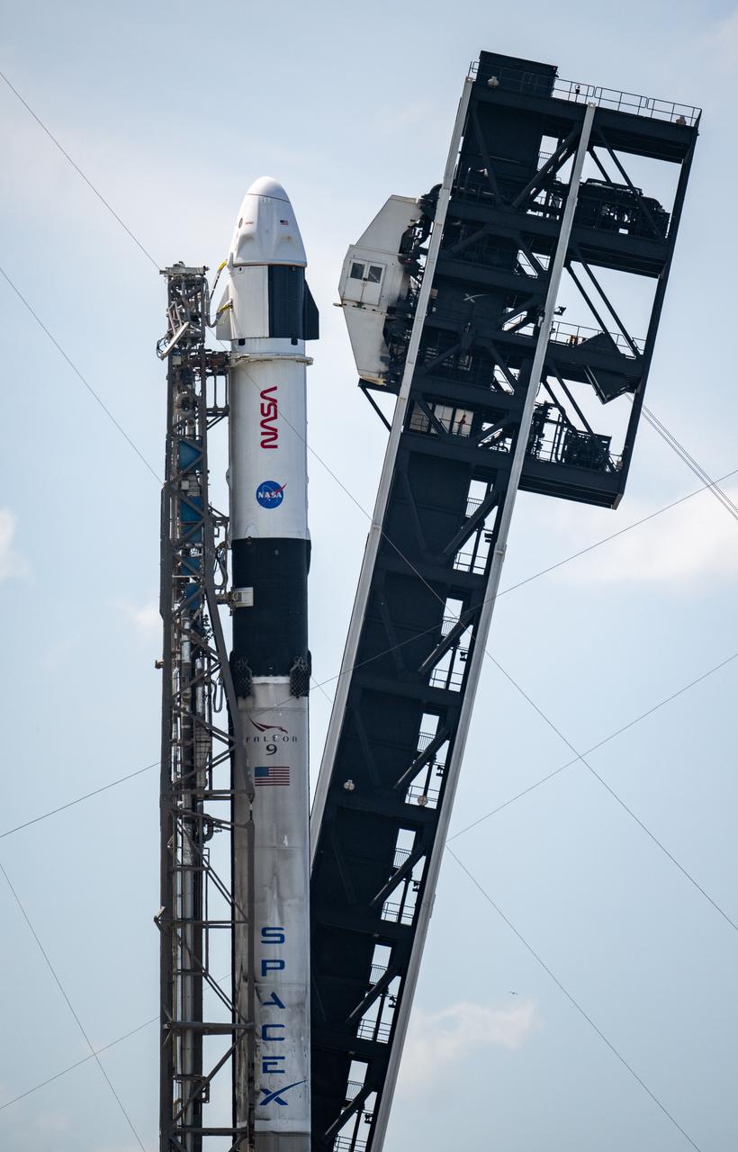 A SpaceX Falcon 9 rocket with the company's Dragon spacecraft on top is seen, photographed at an angle, as it is raised into a vertical position on the launch pad at Space Launch Complex 40 as preparations continue for the Crew-9 mission, Friday, Sept. 27, 2024, at Cape Canaveral Space Force Station in Florida. NASA’s SpaceX Crew-9 mission is the ninth crew rotation mission of the SpaceX Dragon spacecraft and Falcon 9 rocket to the International Space Station as part of the agency’s Commercial Crew Program. NASA astronaut Nick Hague and Roscosmos cosmonaut Aleksandr Gorbunov are scheduled to launch on 1:17 p.m. EDT on Saturday, Sept. 28, from Space Launch Complex 40 at the Cape Canaveral Space Force Station. Photo Credit: (NASA/Keegan Barber)