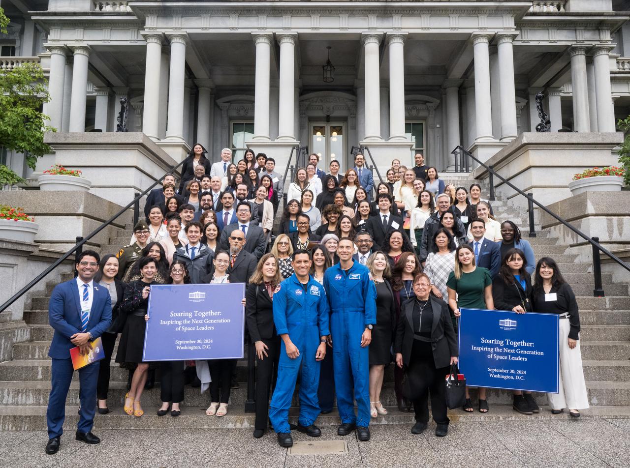 NASA astronauts Frank Rubio, center left, and Marcos Berrios, center right, pose for a photo on the Navy Steps of the Eisenhower Executive Office Building with attendees, panelists, and speakers of the White House Hispanic Heritage month event titled “Soaring Together: Inspiring the Next Generation of Space Leaders” at the Eisenhower Executive Office Building, Monday, Sept. 30, 2024 in Washington. Photo Credit: (NASA/Aubrey Gemignani)