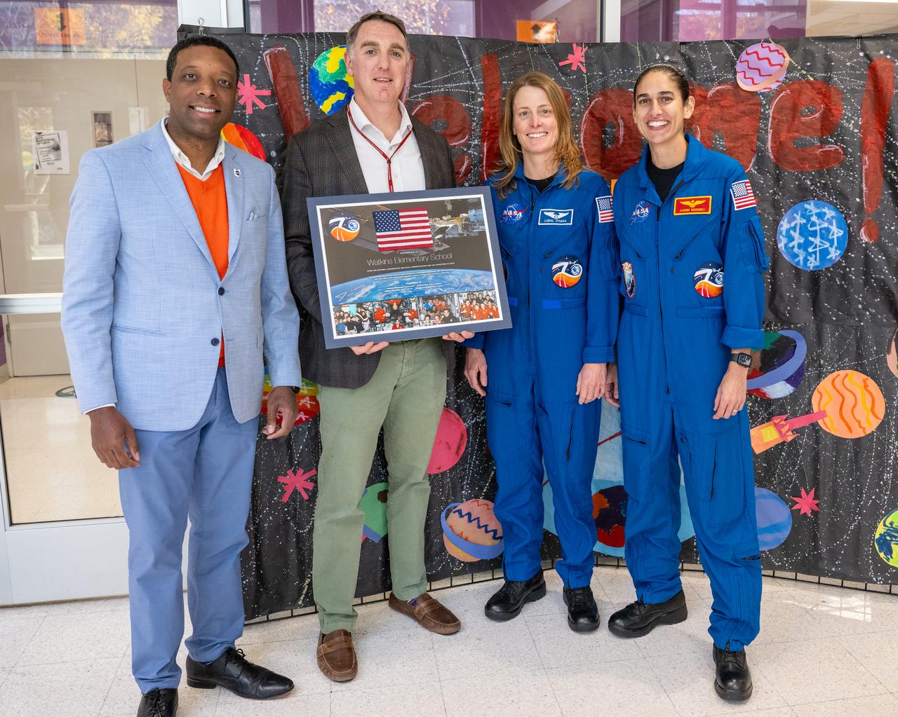 From left to right, Center of Science and Industry (COSI) Chief Strategy Officer Stephen White, Principal MScott Berkowitz, NASA astronauts Loral O’Hara and Jasmin Moghbeli pose for a photo prior to an engagement event at Catherine Watkins Elementary School Monday, Dec. 2, 2024 in Washington. O’Hara and Moghbeli spent six months in space as part of Expedition 70 aboard the International Space Station. Photo Credit: (NASA/Keegan Barber)