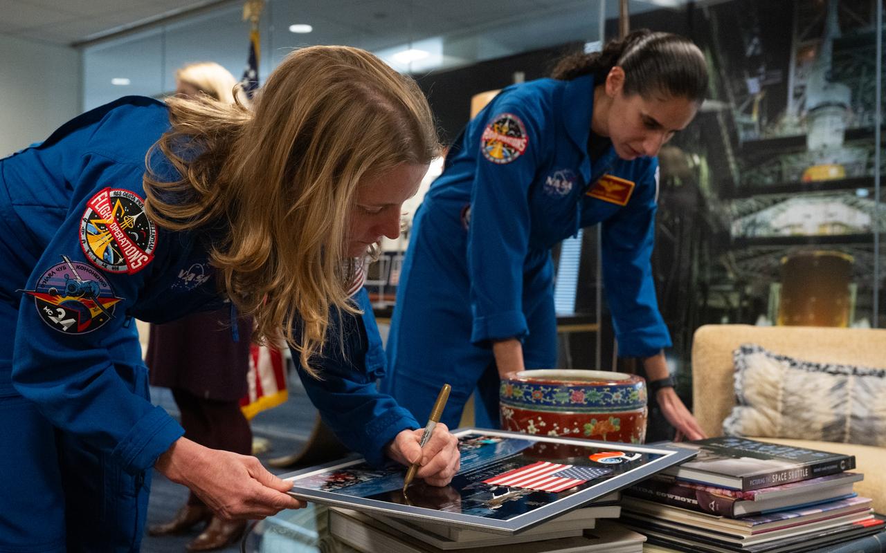 NASA astronauts Loral O’Hara, left, and Jasmin Moghbeli sign montages from their mission to present to NASA Administrator Bill Nelson, NASA Deputy Administrator Pam Melroy, and NASA Associate Administrator Jim Free, Wednesday, Dec. 4, 2024 at the Mary W. Jackson NASA Headquarters Building in Washington. O’Hara and Moghbeli spent six months in space as part of Expedition 70 aboard the International Space Station.  Photo Credit: (NASA/Joel Kowsky)