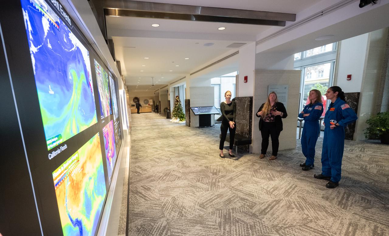 Eleanor Stokes, program manager for NASA’s Earth Information Center, left, and Nicole Ramberg-Pihl, project manager for NASA’s Earth Information Center, second from left, speak with NASA astronauts Loral O’Hara, second from right, and Jasmin Moghbeli, right, during a tour of the Earth Information Center, Wednesday, Dec. 4, 2024, at the Mary W. Jackson NASA Headquarters Building in Washington. O’Hara and Moghbeli spent six months in space as part of Expedition 70 aboard the International Space Station.  Photo Credit: (NASA/Joel Kowsky)