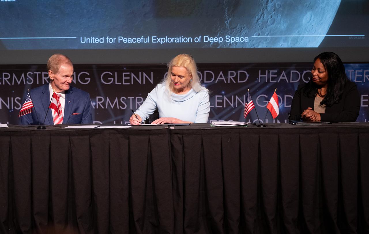 NASA Administrator Bill Nelson, left, and U.S. Department of State Acting Assistant Secretary in the Bureau of Oceans and International Environmental and Scientific Affairs Jennifer R. Littlejohn, right, look on as Ambassador of the Republic of Austria to the United States of America Petra Schneebauer, signs the Artemis Accords, Wednesday, Dec. 11, 2024, at the Mary W. Jackson NASA Headquarters building in Washington. The Republic of Austria is the 50th country to sign the Artemis Accords, which establish a practical set of principles to guide space exploration cooperation among nations participating in NASA’s Artemis program. Photo Credit: (NASA/Joel Kowsky)