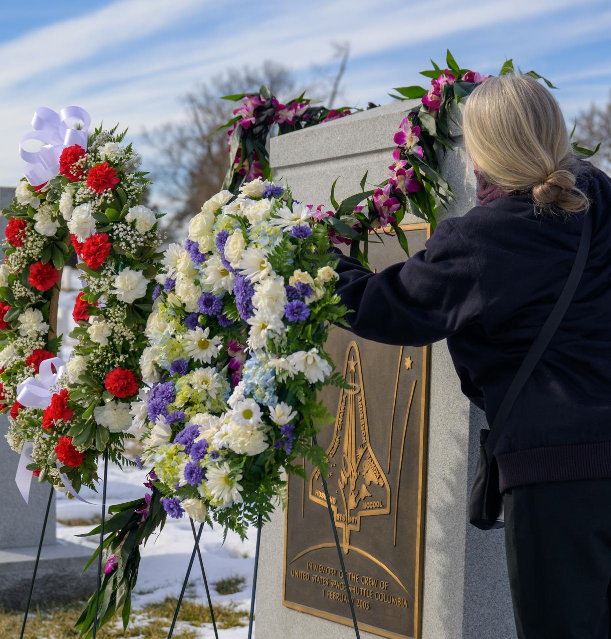 Kristy Carroll, Family friend of the Columbia Mission, places flowers over the Space Shuttle Columbia Memorial during a ceremony that was part of NASA's Day of Remembrance, Thursday, Jan. 23, 2025, at Arlington National Cemetery in Arlington, Va. Wreaths were laid in memory of those men and women who lost their lives in the quest for space exploration.  Photo Credit: (NASA/Bill Ingalls)