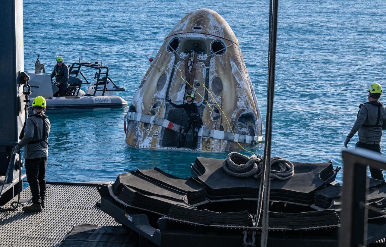Support teams work around a SpaceX Dragon spacecraft shortly after it landed with NASA astronauts Nick Hague, Suni Williams, Butch Wilmore, and Roscosmos cosmonaut Aleksandr Gorbunov aboard in the water off the coast of Tallahassee, Florida, Tuesday, March 18, 2025. Hague, Gorbunov, Williams, and Wilmore are returning from a long-duration science expedition aboard the International Space Station. Photo Credit: (NASA/Keegan Barber)