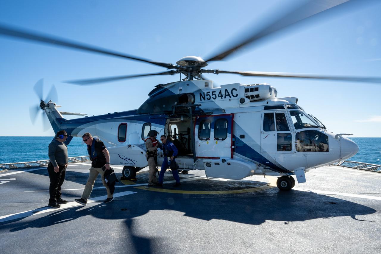 NASA and SpaceX recovery teams exit a helicopter aboard recovery ship MEGAN as they prepare for the landing of a SpaceX Dragon spacecraft with NASA astronauts Nick Hague, Suni Williams, Butch Wilmore, and Roscosmos cosmonaut Aleksandr Gorbunov aboard, Tuesday, March 18, 2025, off the coast of Tallahassee, Florida. Hague, Gorbunov, Williams, and Wilmore are returning from a long-duration science expedition aboard the International Space Station. Photo Credit: (NASA/Keegan Barber)