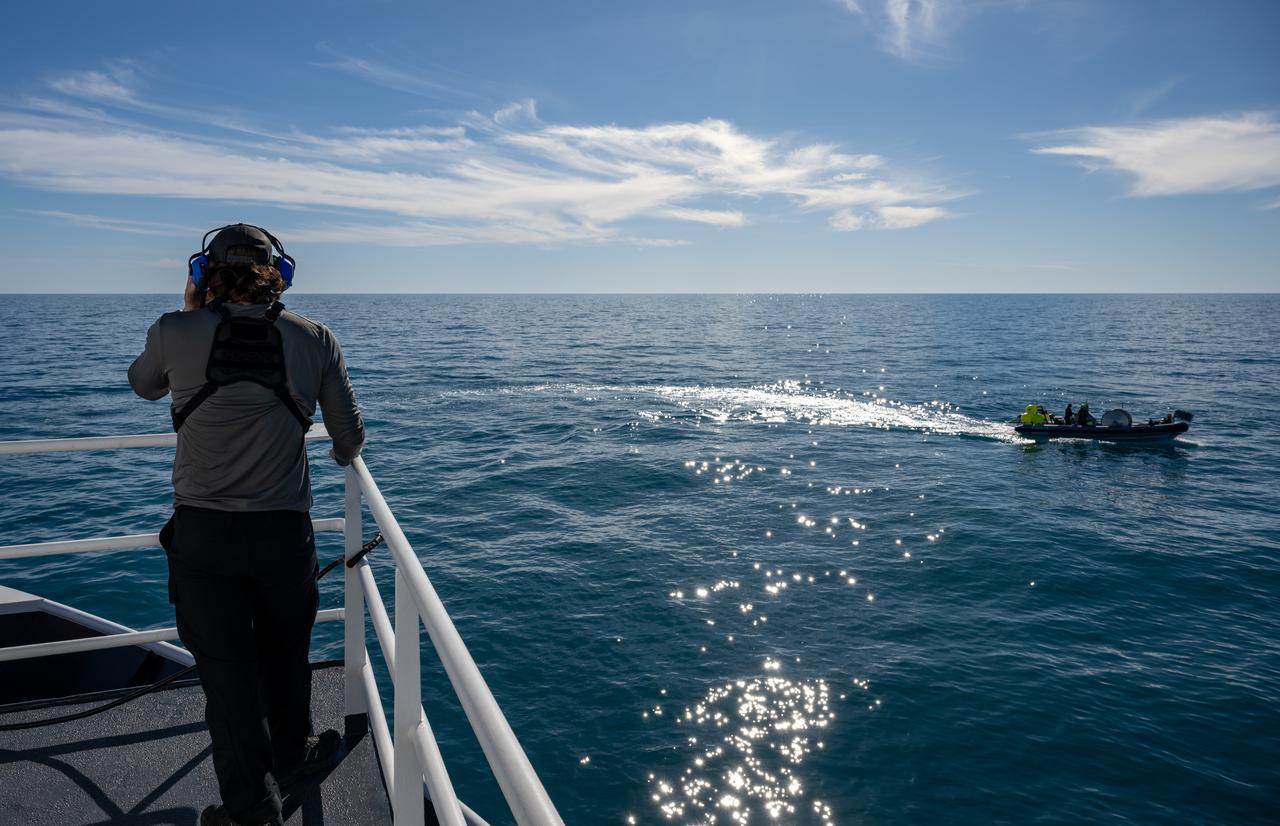 SpaceX fast boat teams are seen alongside recovery ship MEGAN as the recovery team prepares for the landing of a SpaceX Dragon spacecraft with NASA astronauts Nick Hague, Suni Williams, Butch Wilmore, and Roscosmos cosmonaut Aleksandr Gorbunov aboard, Tuesday, March 18, 2025, off the coast of Tallahassee, Florida. Hague, Gorbunov, Williams, and Wilmore are returning from a long-duration science expedition aboard the International Space Station. Photo Credit: (NASA/Keegan Barber)