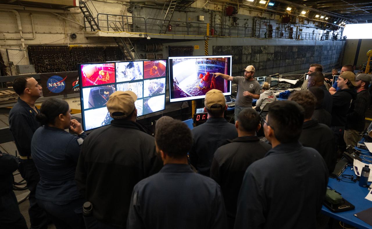 Teams gather as they prepare for the first day of Underway Recovery Test-12 onboard USS Somerset, Tuesday, March 25, 2025. During the test, NASA and Department of Defense teams are practicing to ensure recovery procedures are validated as NASA plans to send the Artemis II astronauts around the Moon and splashdown in the Pacific Ocean.  Photo Credit: (NASA/Joel Kowsky)