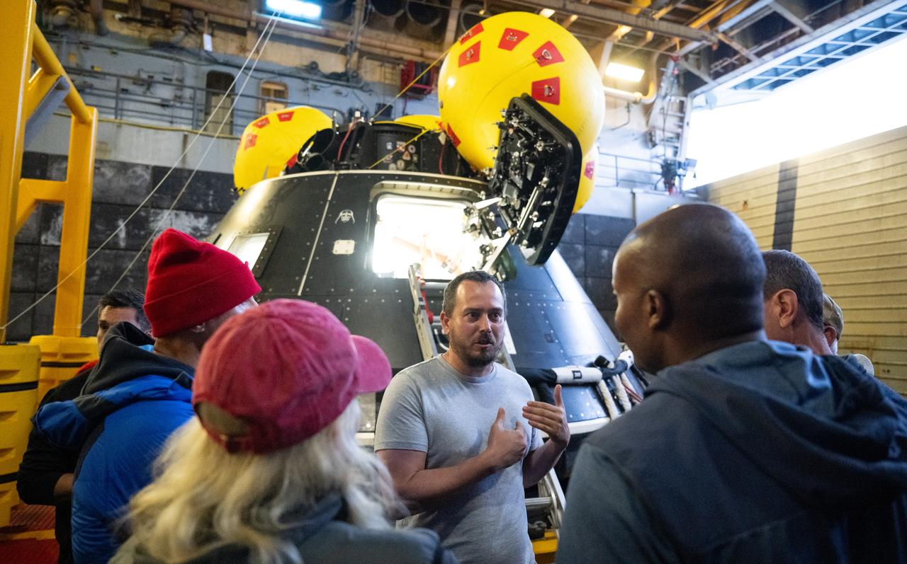 Bert Kallio, lead mechanical engineer for the Crew Module Test Article (CMTA), speaks with NASA astronauts Stan Love, Andre Douglas, Deniz Burnham, and ESA (European Space Agency) astronaut Luca Parmitano during a familiarization walkthrough as part of Underway Recovery Test-12 onboard USS Somerset, Tuesday, March 25, 2025. During the test, NASA and Department of Defense teams are practicing to ensure recovery procedures are validated as NASA plans to send the Artemis II astronauts around the Moon and splashdown in the Pacific Ocean.  Photo Credit: (NASA/Joel Kowsky)