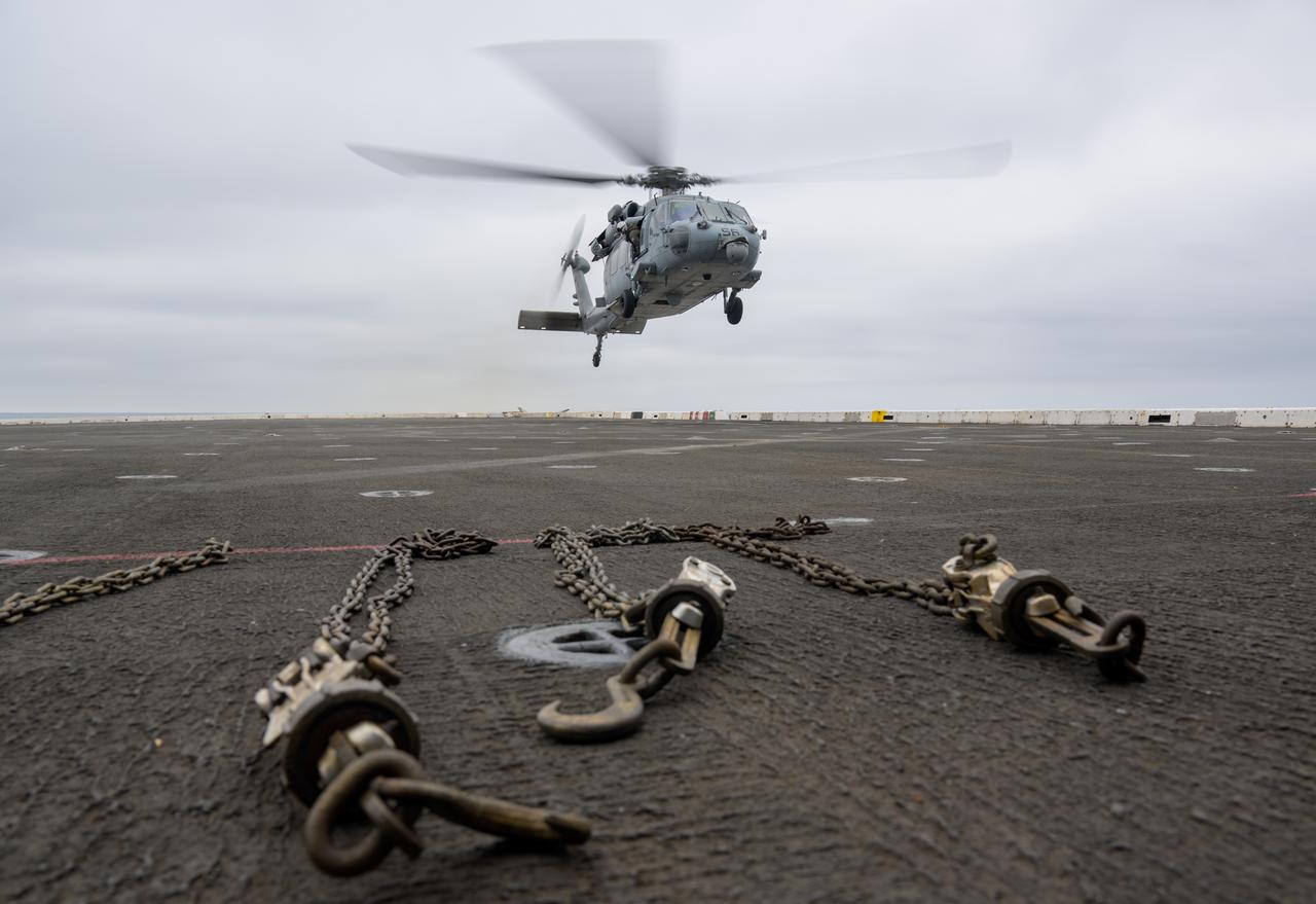 A helicopter lands on USS Somerset off the coast of California, as NASA and Department of Defense teams participate in Underway Recovery Test-12, Tuesday, March 25, 2025. During the test, teams are practicing to ensure recovery procedures are validated as NASA plans to send the Artemis II astronauts around the Moon and splashdown in the Pacific Ocean.  Photo Credit: (NASA/Bill Ingalls)