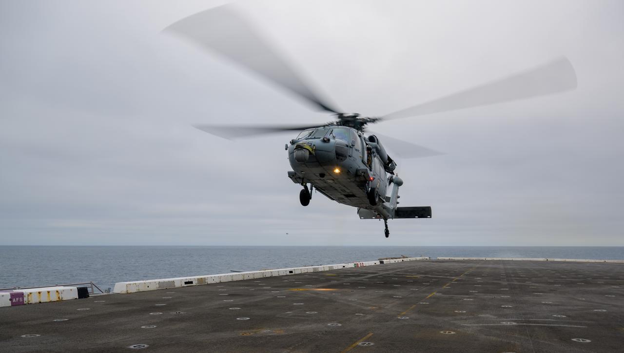 A helicopter lands on USS Somerset off the coast of California, as NASA and Department of Defense teams participate in Underway Recovery Test-12, Tuesday, March 25, 2025. During the test, teams are practicing to ensure recovery procedures are validated as NASA plans to send the Artemis II astronauts around the Moon and splashdown in the Pacific Ocean.  Photo Credit: (NASA/Bill Ingalls)