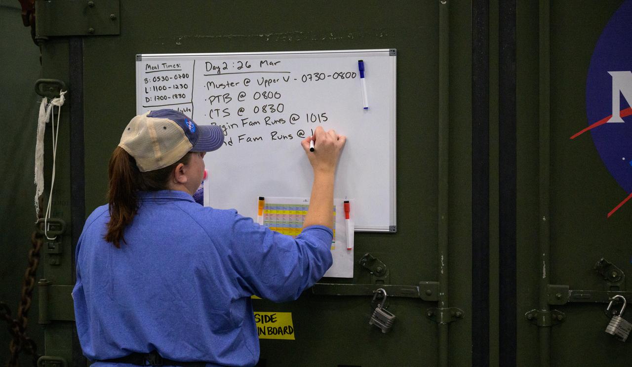 The daily schedule is posted during the Underway Recovery Test-12 onboard USS Somerset off the coast of California, Wednesday, March 26, 2025. During the test, NASA and Department of Defense teams are practicing to ensure recovery procedures are validated as NASA plans to send Artemis II astronauts around the Moon and splashdown in the Pacific Ocean.  Photo Credit: (NASA/Joel Kowsky)