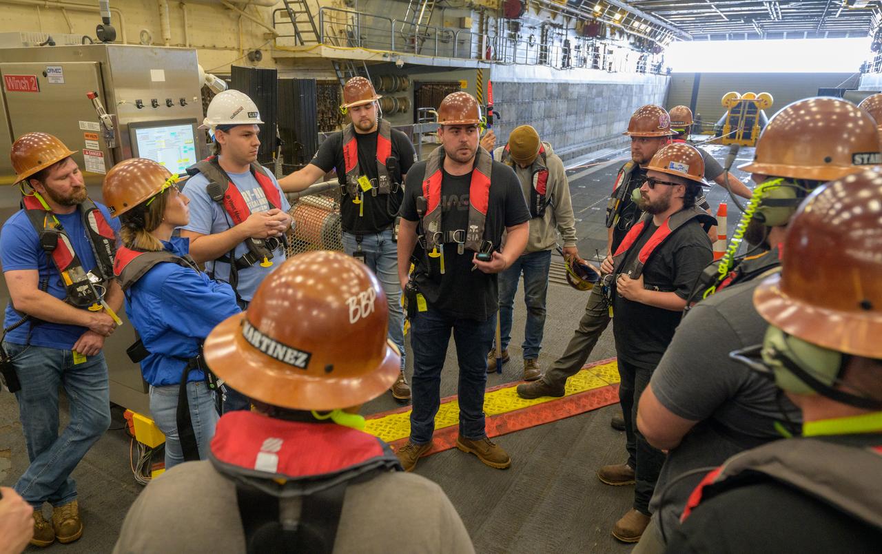 Teams gather as they prepare the Crew Module Test Article (CMTA), a full scale mockup of the Orion spacecraft, during the Underway Recovery Test-12 onboard USS Somerset off the coast of California, Wednesday, March 26, 2025. During the test, NASA and Department of Defense teams are practicing to ensure recovery procedures are validated as NASA plans to send Artemis II astronauts around the Moon and splashdown in the Pacific Ocean. Photo Credit: (NASA/Joel Kowsky)