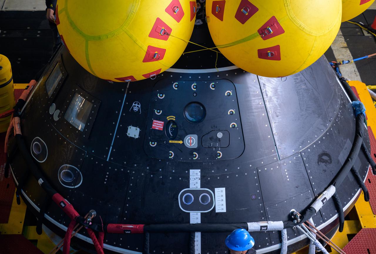 The Crew Module Test Article (CMTA), a full scale mockup of the Orion spacecraft, sits nestled in its cradle during Underway Recovery Test-12 onboard USS Somerset off the coast of California, Wednesday, March 26, 2025. During the test, NASA and Department of Defense teams are practicing to ensure recovery procedures are validated as NASA plans to send Artemis II astronauts around the Moon and splashdown in the Pacific Ocean. Photo Credit: (NASA/Bill Ingalls)