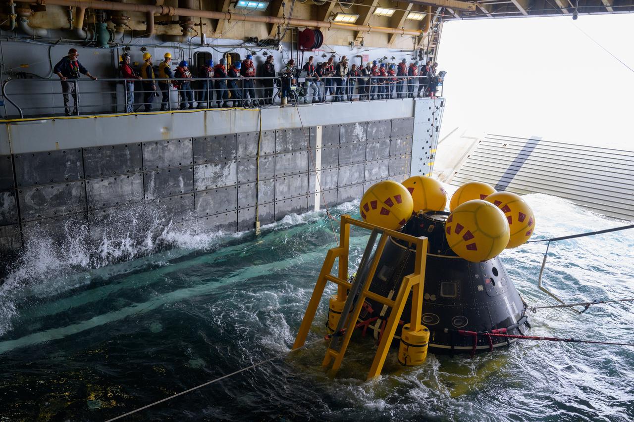 The Crew Module Test Article (CMTA), a full scale mockup of the Orion spacecraft, sits nestled in its cradle during Underway Recovery Test-12 onboard USS Somerset off the coast of California, Wednesday, March 26, 2025. During the test, NASA and Department of Defense teams are practicing to ensure recovery procedures are validated as NASA plans to send Artemis II astronauts around the Moon and splashdown in the Pacific Ocean. Photo Credit: (NASA/Bill Ingalls)