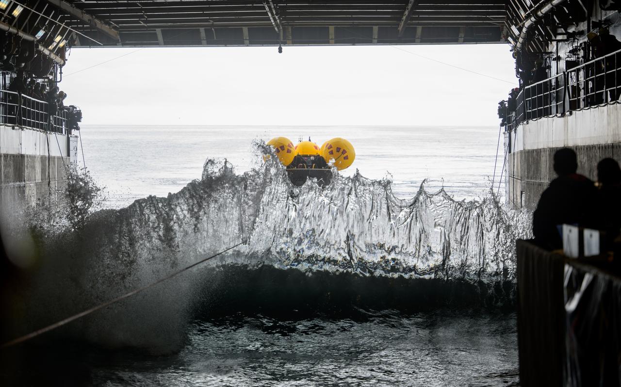 Waves break inside USS Somerset as the Crew Module Test Article (CMTA), a full scale mockup of the Orion spacecraft, is tethered during Underway Recovery Test-12 off the coast of California, Wednesday, March 26, 2025. During the test, NASA and Department of Defense teams are practicing to ensure recovery procedures are validated as NASA plans to send Artemis II astronauts around the Moon and splashdown in the Pacific Ocean. Photo Credit: (NASA/Joel Kowsky)