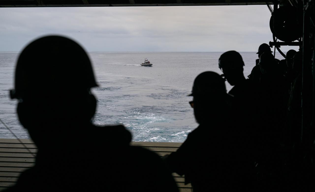 Mission support teams are seen off the stern of USS Somerset as they practice with the Crew Module Test Article (CMTA), a full scale mockup of the Orion spacecraft, during Underway Recovery Test-12 off the coast of California, Wednesday, March 26, 2025. During the test, NASA and Department of Defense teams are practicing to ensure recovery procedures are validated as NASA plans to send Artemis II astronauts around the Moon and splashdown in the Pacific Ocean.  Photo Credit: (NASA/Bill Ingalls)