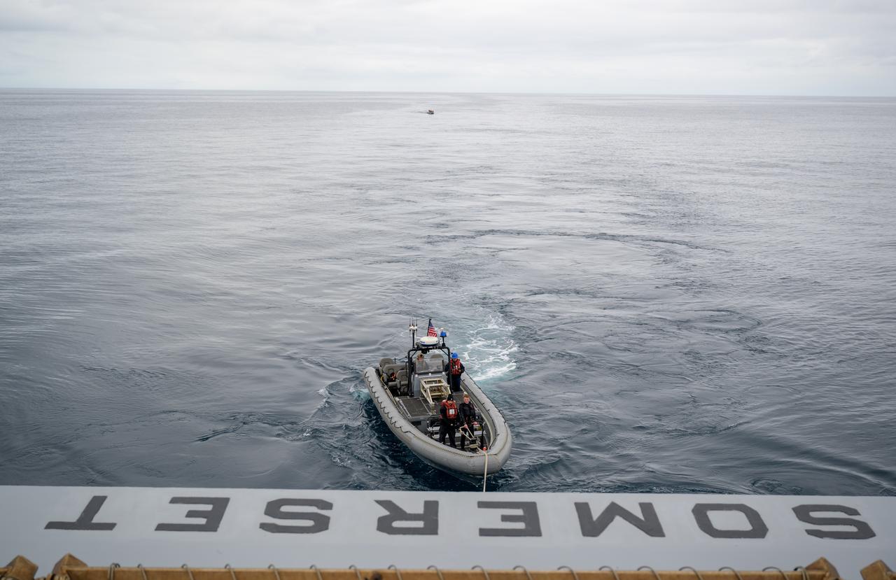 Mission support teams are seen off the stern of USS Somerset as they practice with the Crew Module Test Article (CMTA), a full scale mockup of the Orion spacecraft, during Underway Recovery Test-12 off the coast of California, Wednesday, March 26, 2025. During the test, NASA and Department of Defense teams are practicing to ensure recovery procedures are validated as NASA plans to send Artemis II astronauts around the Moon and splashdown in the Pacific Ocean.  Photo Credit: (NASA/Joel Kowsky)