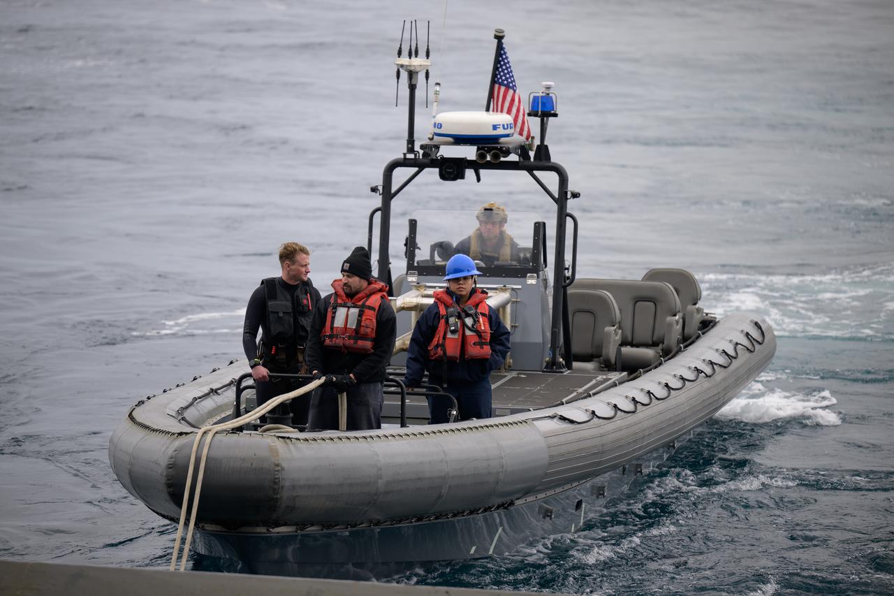 Mission support teams are seen off the stern of USS Somerset as they practice with the Crew Module Test Article (CMTA), a full scale mockup of the Orion spacecraft, during Underway Recovery Test-12 off the coast of California, Wednesday, March 26, 2025. During the test, NASA and Department of Defense teams are practicing to ensure recovery procedures are validated as NASA plans to send Artemis II astronauts around the Moon and splashdown in the Pacific Ocean.  Photo Credit: (NASA/Bill Ingalls)