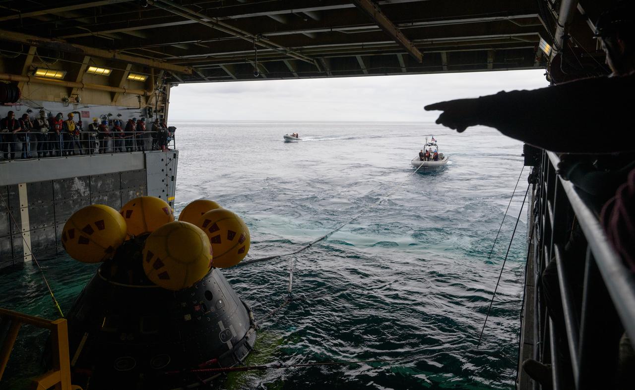 Mission support teams are seen off the stern of USS Somerset as they practice with the Crew Module Test Article (CMTA), a full scale mockup of the Orion spacecraft, during Underway Recovery Test-12 off the coast of California, Wednesday, March 26, 2025. During the test, NASA and Department of Defense teams are practicing to ensure recovery procedures are validated as NASA plans to send Artemis II astronauts around the Moon and splashdown in the Pacific Ocean.  Photo Credit: (NASA/Bill Ingalls)