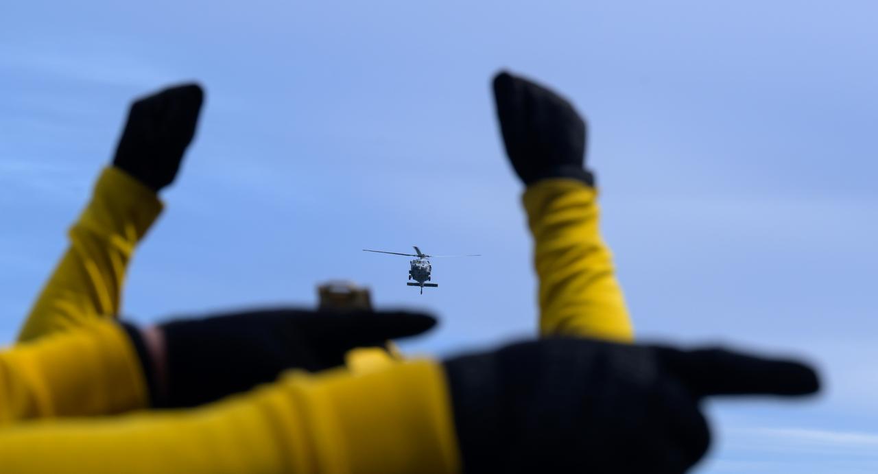 USS Somerset sailors direct the landing of helicopters with astronauts onboard during Underway Recovery Test-12 onboard USS Somerset off the coast of California, Thursday, March 27, 2025. During the test, NASA and Department of Defense teams are practicing to ensure recovery procedures are validated as NASA plans to send Artemis II astronauts around the Moon and splashdown in the Pacific Ocean.  Photo Credit: (NASA/Bill Ingalls)