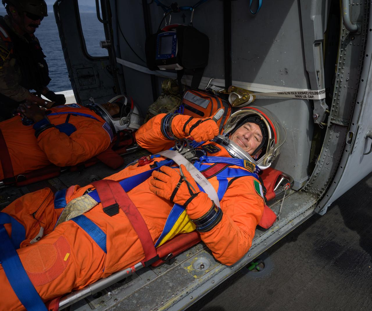 ESA (European Space Agency) astronaut Luca Parmitano, foreground, and NASA astronaut Andre Douglas, are seen in a Navy helicopter onboard USS Somerset during Underway Recovery Test-12 off the coast of California, Thursday, March 27, 2025. During the test, NASA and Department of Defense teams are practicing to ensure recovery procedures are validated as NASA plans to send Artemis II astronauts around the Moon and splashdown in the Pacific Ocean.  Photo Credit: (NASA/Bill Ingalls)