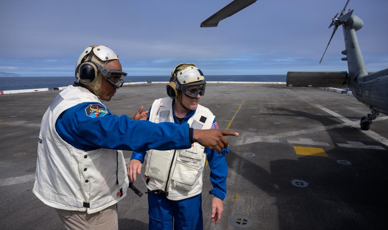 NASA astronaut Victor Glover, left, and NASA Flight Surgeon Richard Scheuring, are seen on the flight deck of USS Somerset during Underway Recovery Test-12 off the coast of California, Thursday, March 27, 2025. During the test, NASA and Department of Defense teams are practicing to ensure recovery procedures are validated as NASA plans to send Artemis II astronauts around the Moon and splashdown in the Pacific Ocean.  Photo Credit: (NASA/Bill Ingalls)