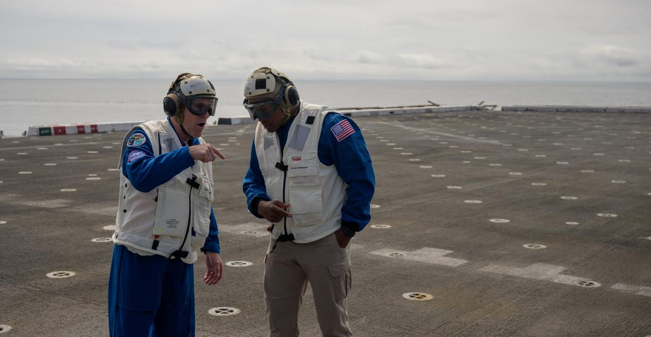 NASA astronaut Victor Glover, left, and NASA Flight Surgeon Richard Scheuring, are seen on the flight deck of USS Somerset during Underway Recovery Test-12 off the coast of California, Thursday, March 27, 2025. During the test, NASA and Department of Defense teams are practicing to ensure recovery procedures are validated as NASA plans to send Artemis II astronauts around the Moon and splashdown in the Pacific Ocean. Photo Credit: (NASA/Bill Ingalls)