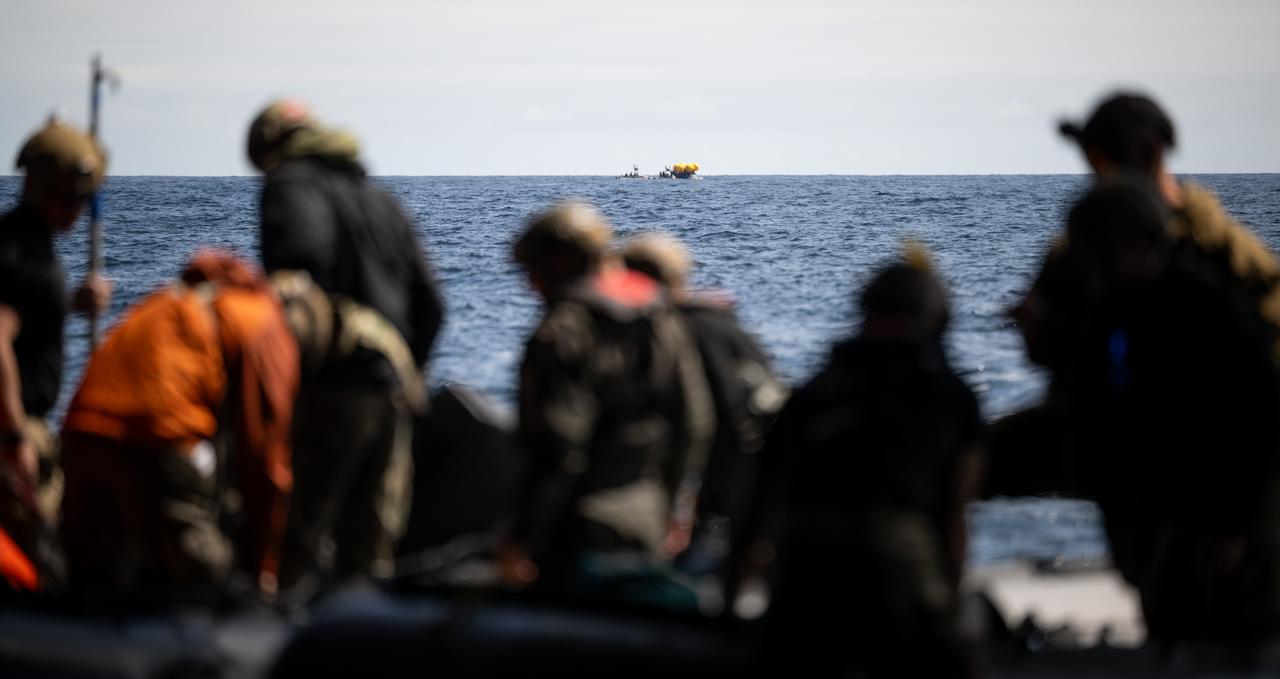 The Crew Module Test Article (CMTA) is seen in the Pacific Ocean as Navy Divers of Explosive Ordnance Disposal Expeditionary Support Unit (EODESU) 1 prepare to take part in practicing Artemis recovery operations during Underway Recovery Test-12 onboard USS Somerset off the coast of California, Thursday, March 27, 2025. During the test, NASA and Department of Defense teams are practicing to ensure recovery procedures are validated as NASA plans to send the Artemis II astronauts around the Moon and splashdown in the Pacific Ocean.  Photo Credit: (NASA/Joel Kowsky)