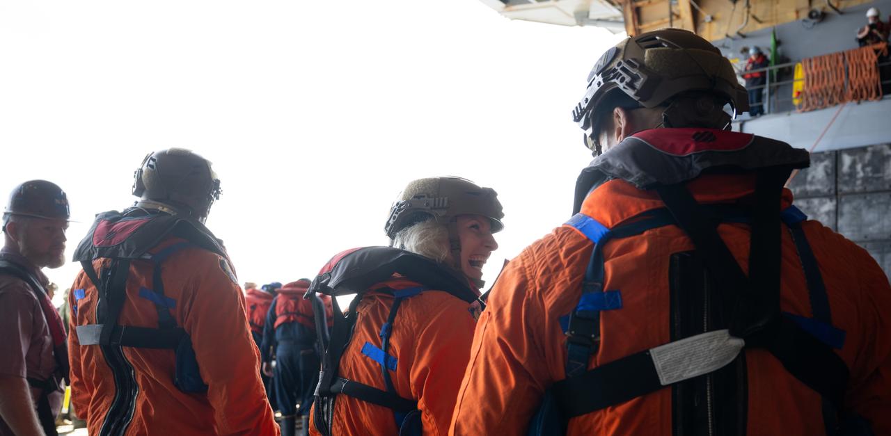 NASA astronaut Deniz Burnham, center, talks with ESA (European Space Agency) astronaut Luca Parmitano as they take part in practicing Artemis recovery operations with fellow NASA astronaut and Artemis II backup crew member Andre Douglas during Underway Recovery Test-12 onboard USS Somerset off the coast of California, Thursday, March 27, 2025. During the test, NASA and Department of Defense teams are practicing to ensure recovery procedures are validated as NASA plans to send the Artemis II astronauts around the Moon and splashdown in the Pacific Ocean.  Photo Credit: (NASA/Joel Kowsky)